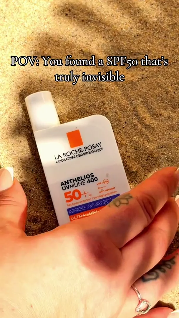 La Roche-Posay Anthelios UVMune 400 SPF 50+ held in hand on sandy beach, lifestyle skincare UGC content UK BeautyWithJu